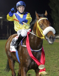 Thrilled! Sean Veale salutes in the winner's enclosure in front of the stands