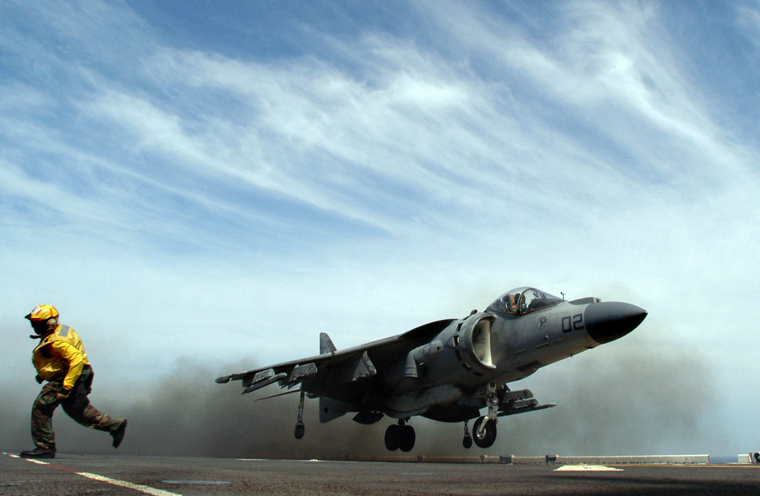 050423-N-6214F-004 Atlantic Ocean (April 23, 2005) - Aviation Boatswain's Mate 2nd Class Courtney F. Godfrey runs behind the foul line as a Marine Corps AV-8B Harrier II+, assigned to the ÒBulldogsÓ of Marine Attack Squadron Two Two Three (VMA-223), performs a vertical takeoff from the flight deck of the amphibious assault ship USS Iwo Jima (LHD 7). The AV-8B is a high performance, single-engine, single-seat, Vertical/Short Take-off and Landing (V/STOL) attack aircraft. The AV-8B Harrier II+ is capable of night and adverse weather operations due to the addition of the AN/APG-65 multi-mode radar. The fusion of night and radar capabilities allows the Harrier to be responsive to the Marine Air-Ground Task Force's needs for expeditionary, night and adverse weather, offensive air support. Iwo Jima is currently conducting training operations in the Atlantic Ocean. U.S. Navy photo by Photographer's Mate 1st Class Robet J. Fluegel (RELEASED)