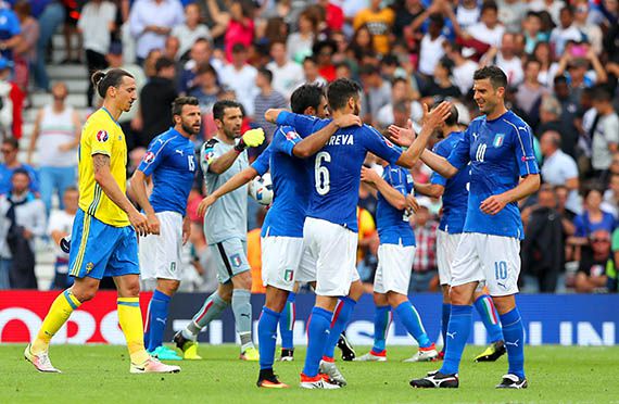 Italy players celebrate their win as Sweden's Zlatan Ibrahimovic leaves the pitch after the final whistle.