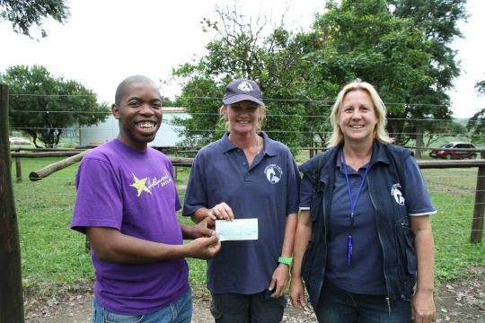 Hollywood's Wiseman Gwala hands over a cheque to Vanessa Beets and Gill Olmesdahl of the KZN Coastal Horse Care Unit.