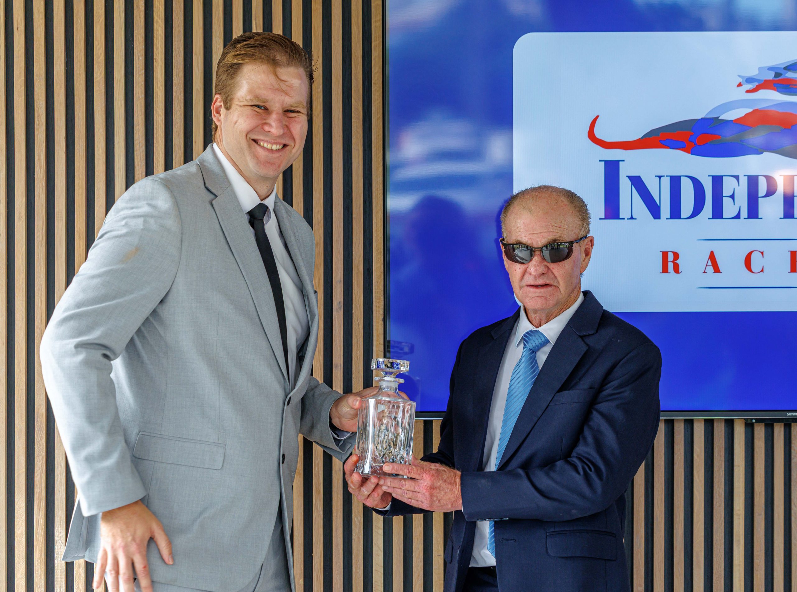 Hollywoodbets Brand and Communication Manager, Devin Heffer hands over the trophy to trainer Peter Muscutt (Pic - Candiese Lenferna)
